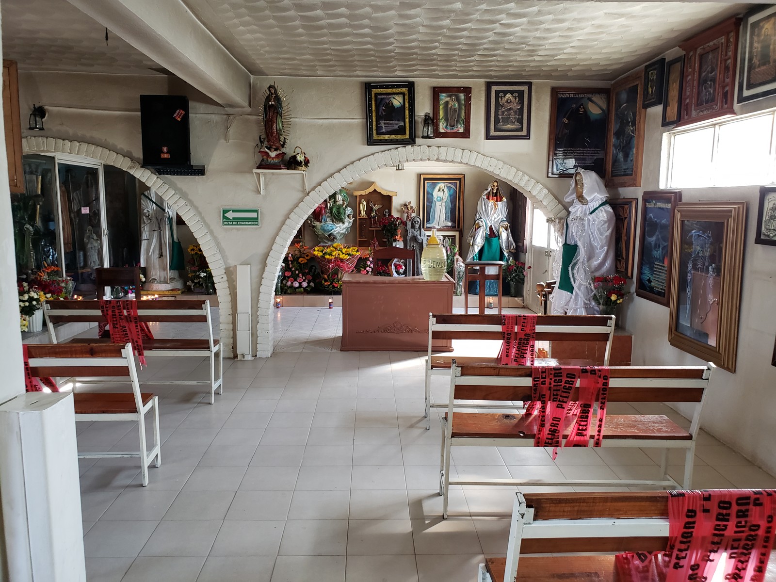Empty chairs and Santa Muerte figures inside the sanctuary in Querétaro.